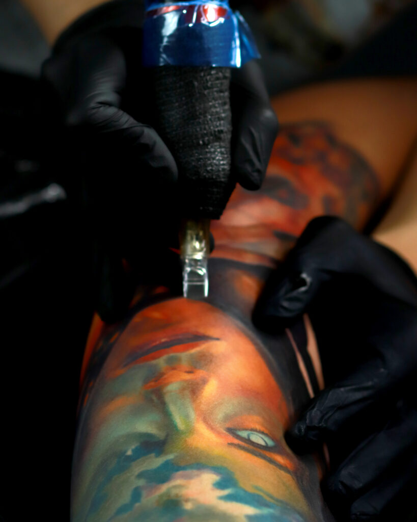 Artist working on a realism portrait tattoo