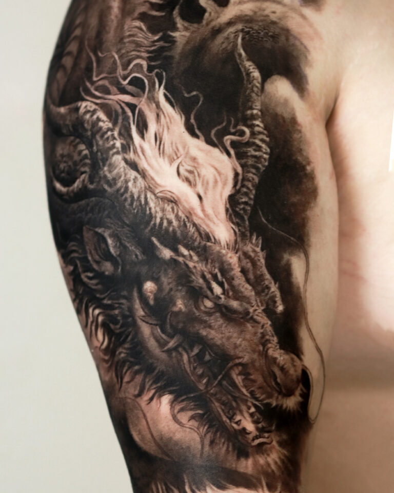 Dragon Black and Grey Realism tattoo on the upper arm.